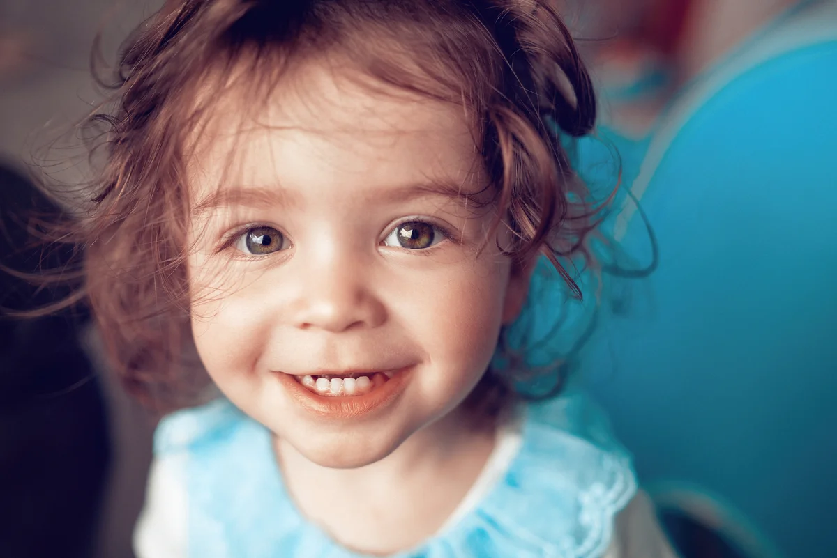 Adorable baby girl looking at camera and playing