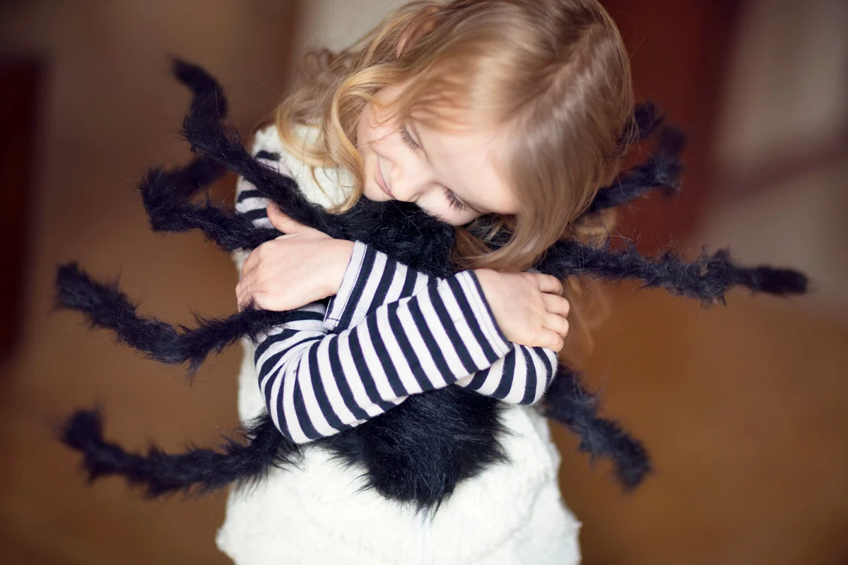 Girl hugging large toy spider