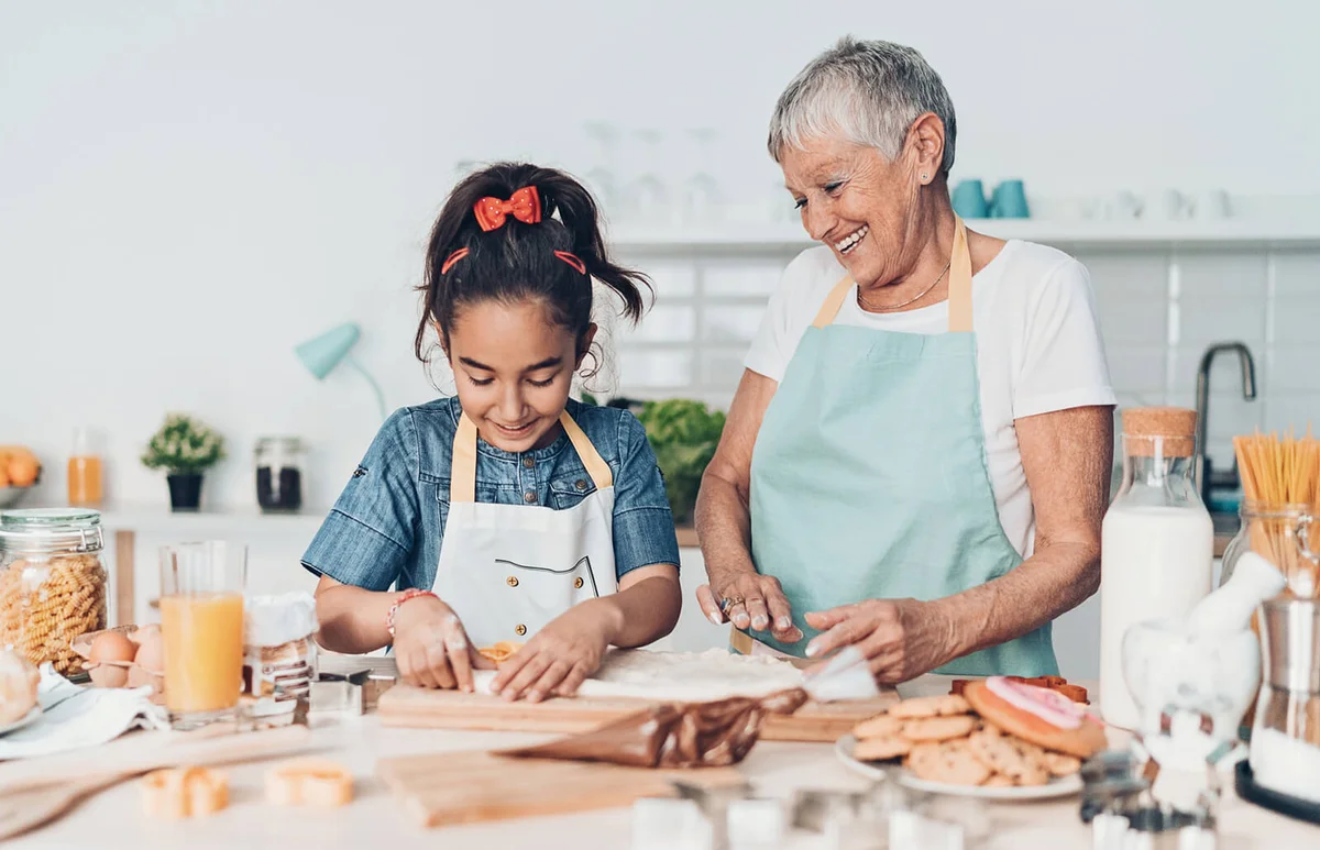 woman teaching a girl to make pastry dough