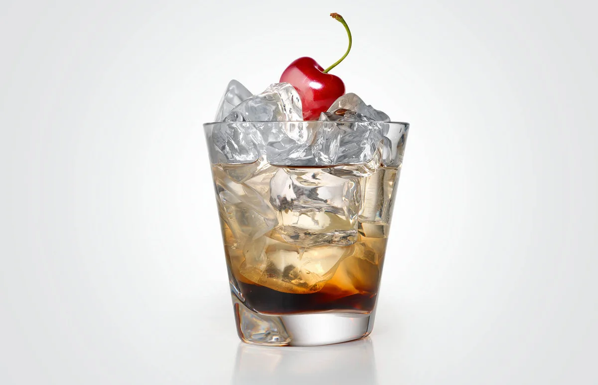 Black russian cocktail with ice and cherry