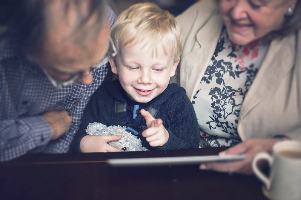 Happy child and Grandparents using a tablet