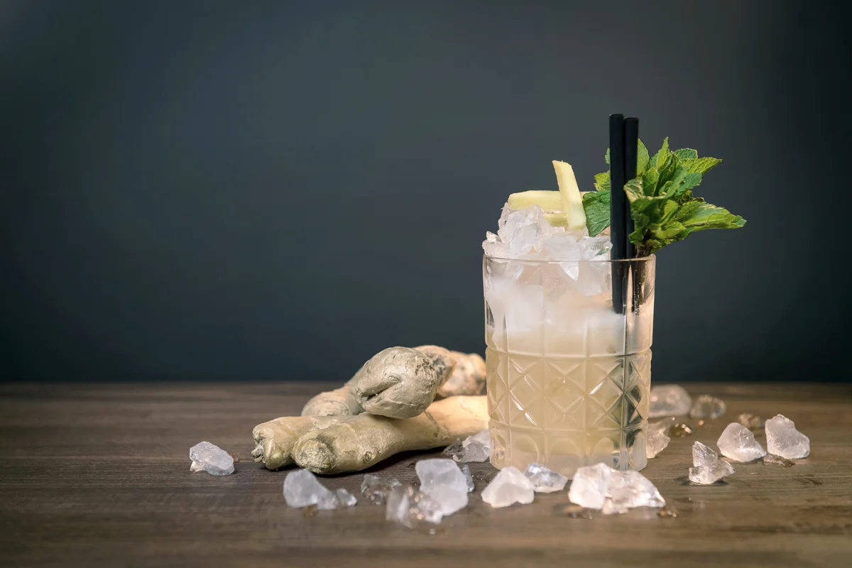 Cocktail Glass And Ginger On Table Against Wall