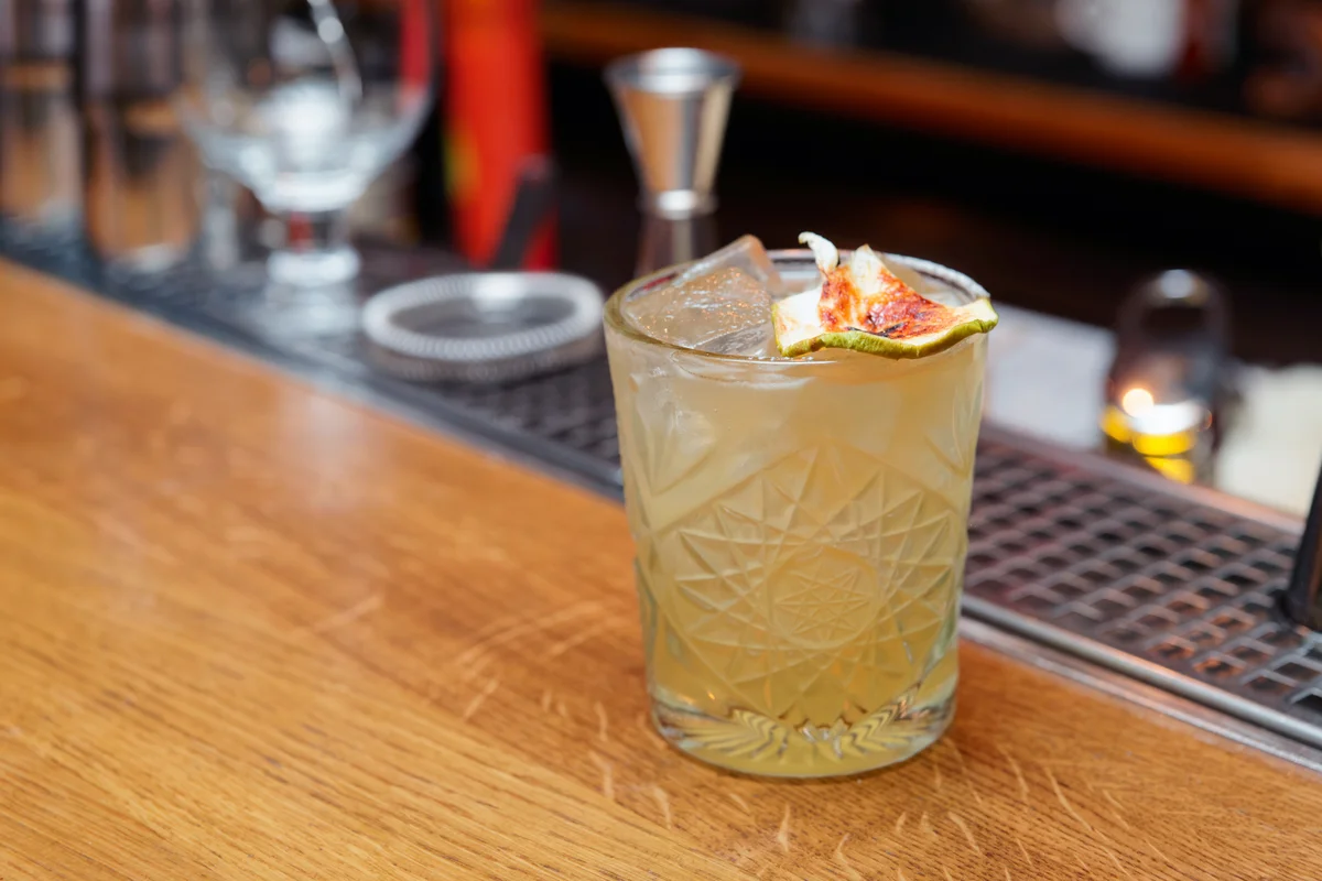 Simple cocktail with apple chips on bar counter