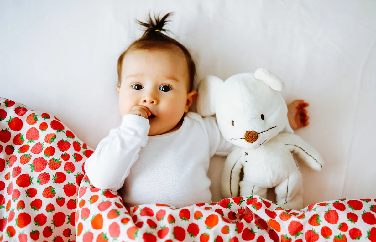 Adorable baby girl is lying in the bed