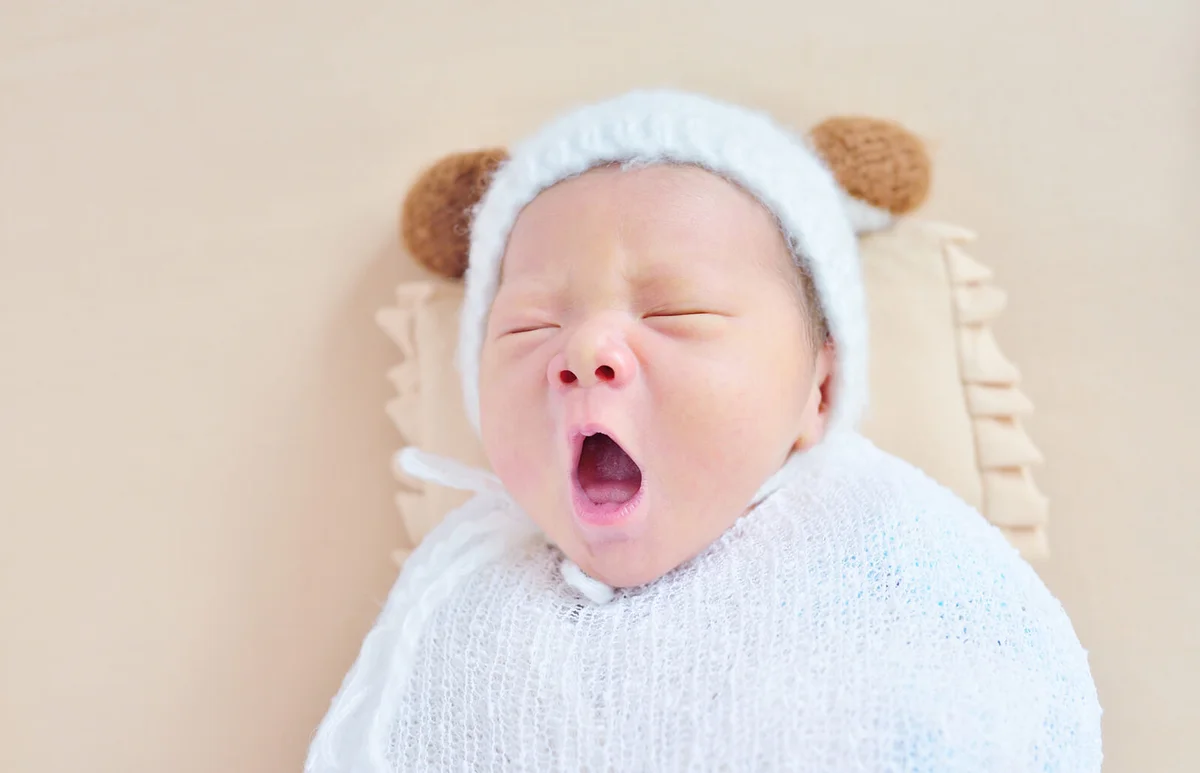 Close-up of newborn at beige sheets background