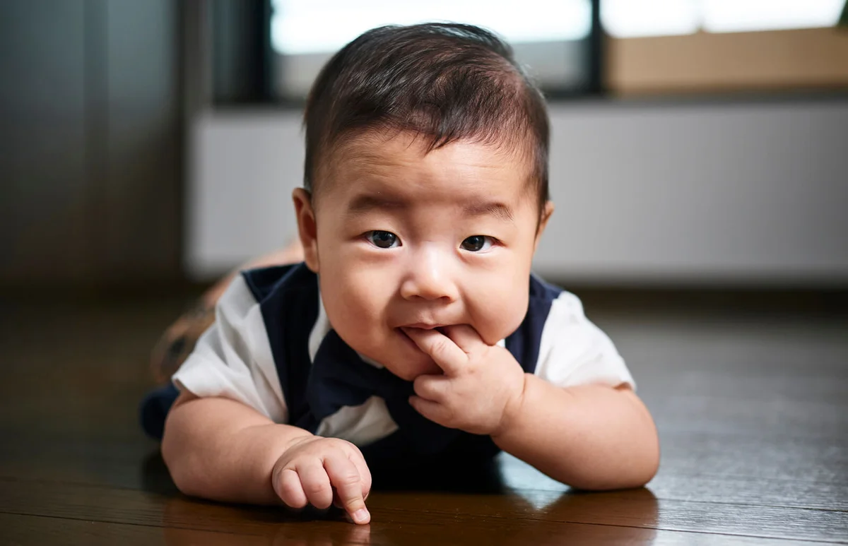 A six month old baby boy inside a home