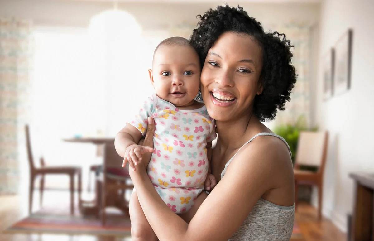 Mother holding baby in living room