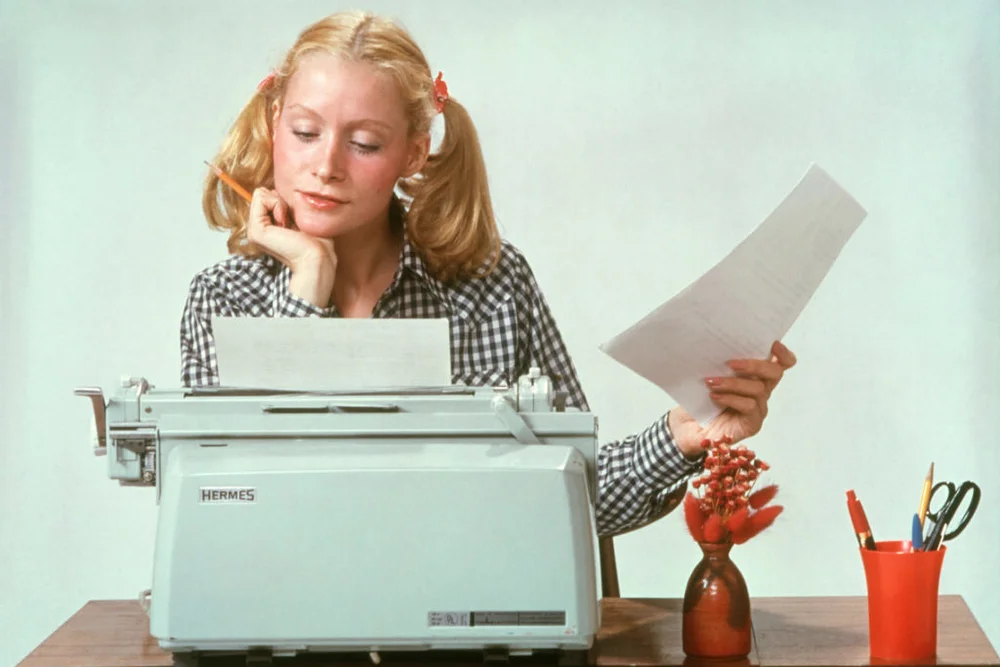 1970s Young Woman using an Hermes Typewriter