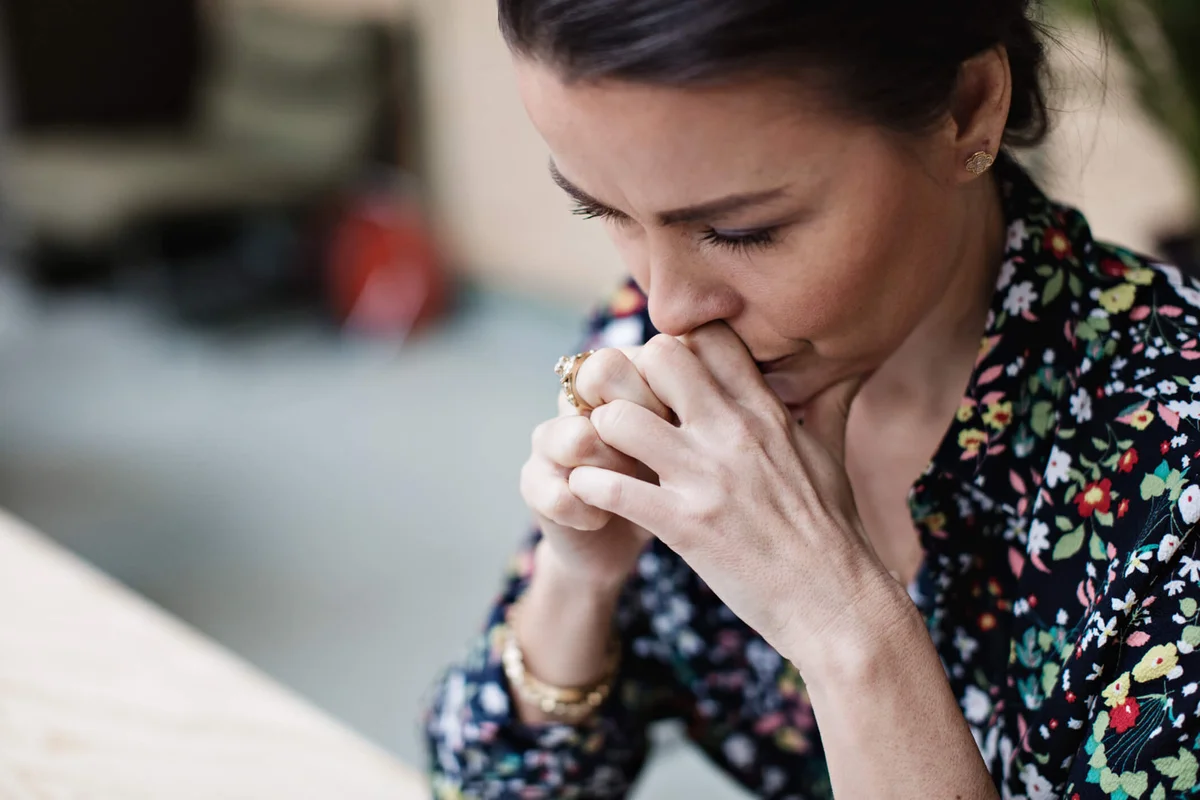tired thoughtful businesswoman with arms crossed at office