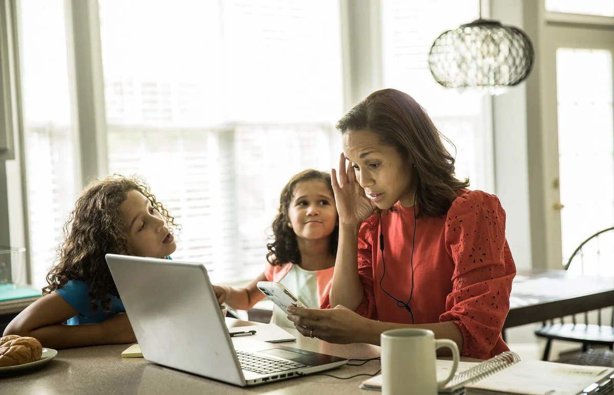 Mother working from home with children in background