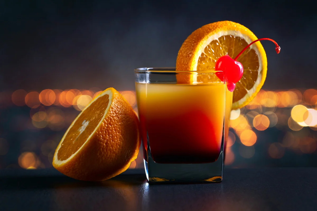 Cocktail Hurricane Sunrise on a background of night city