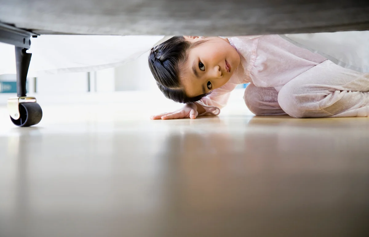 Girl looking under bed