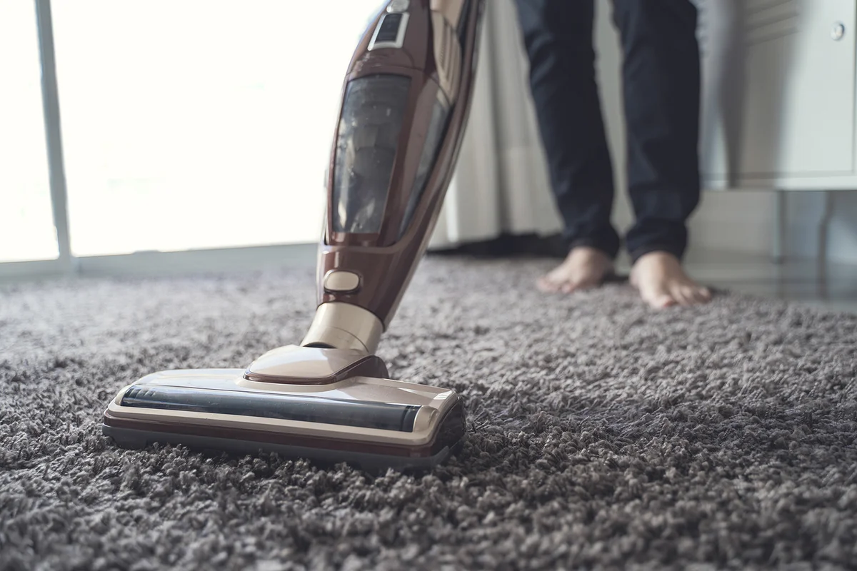 Man Cleaning Carpet With Vacuum Cleaner