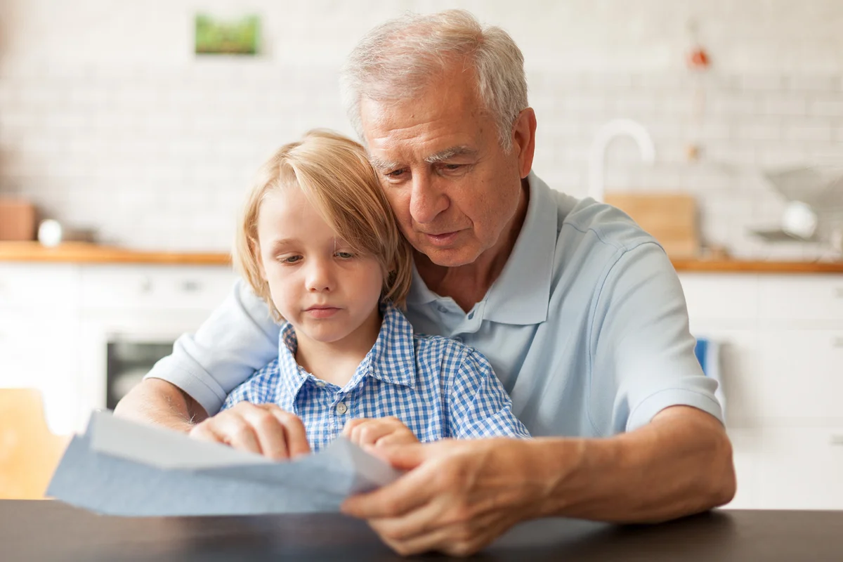 grandfather reading letter with his little boy