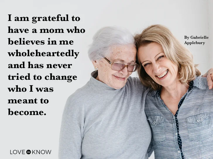 Portrait of senior woman holding hands with daughter and mother's day quote