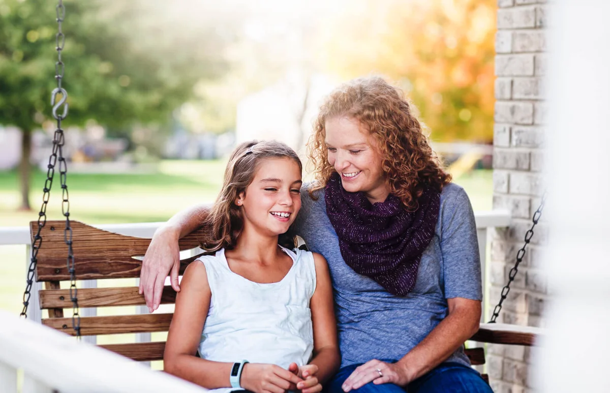 Aunt and niece sitting on porch swing