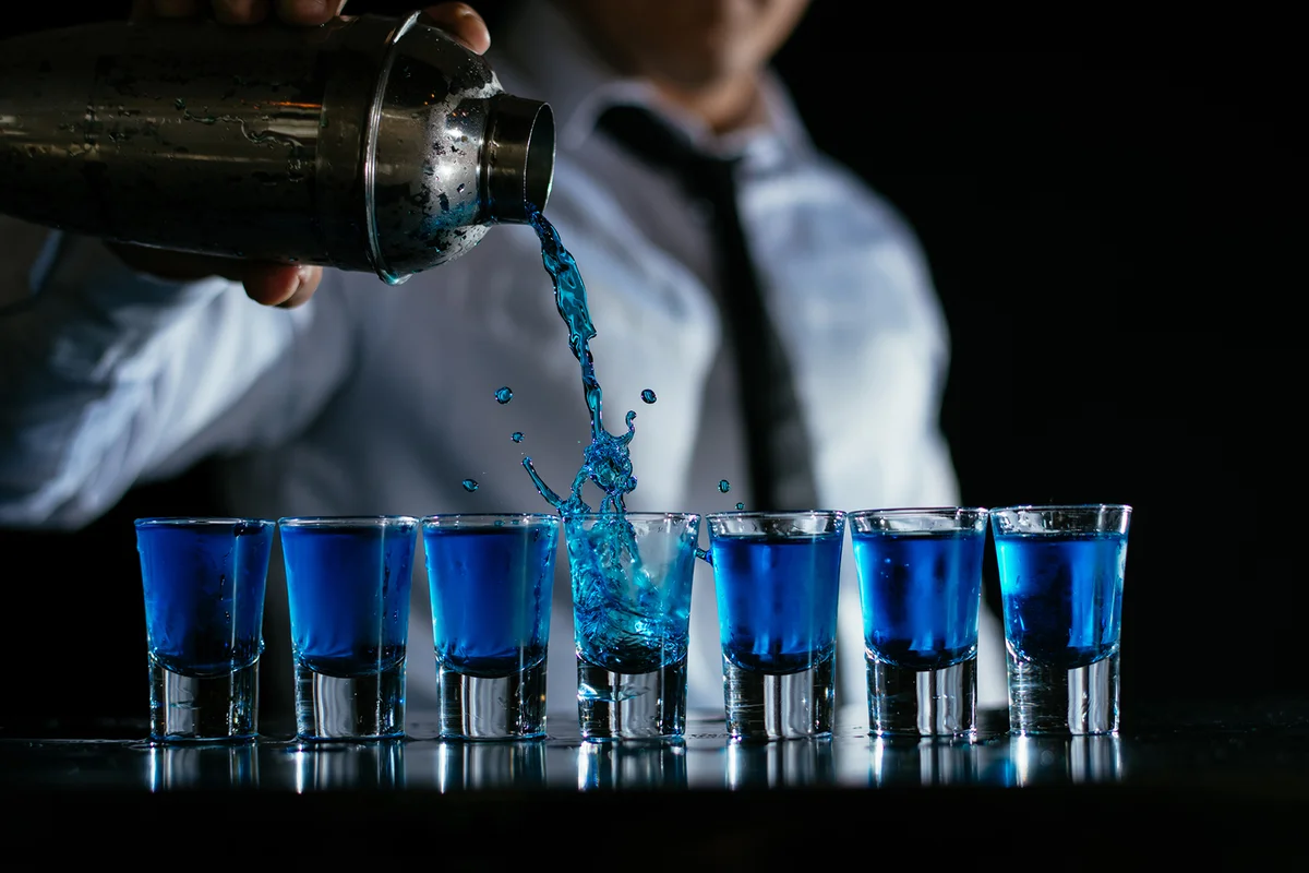 Pouring blue cocktail shots