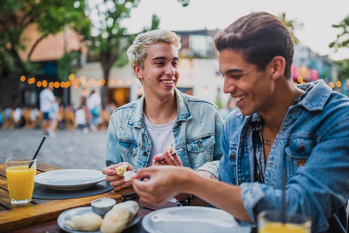 Young gay couple in a street restaurant