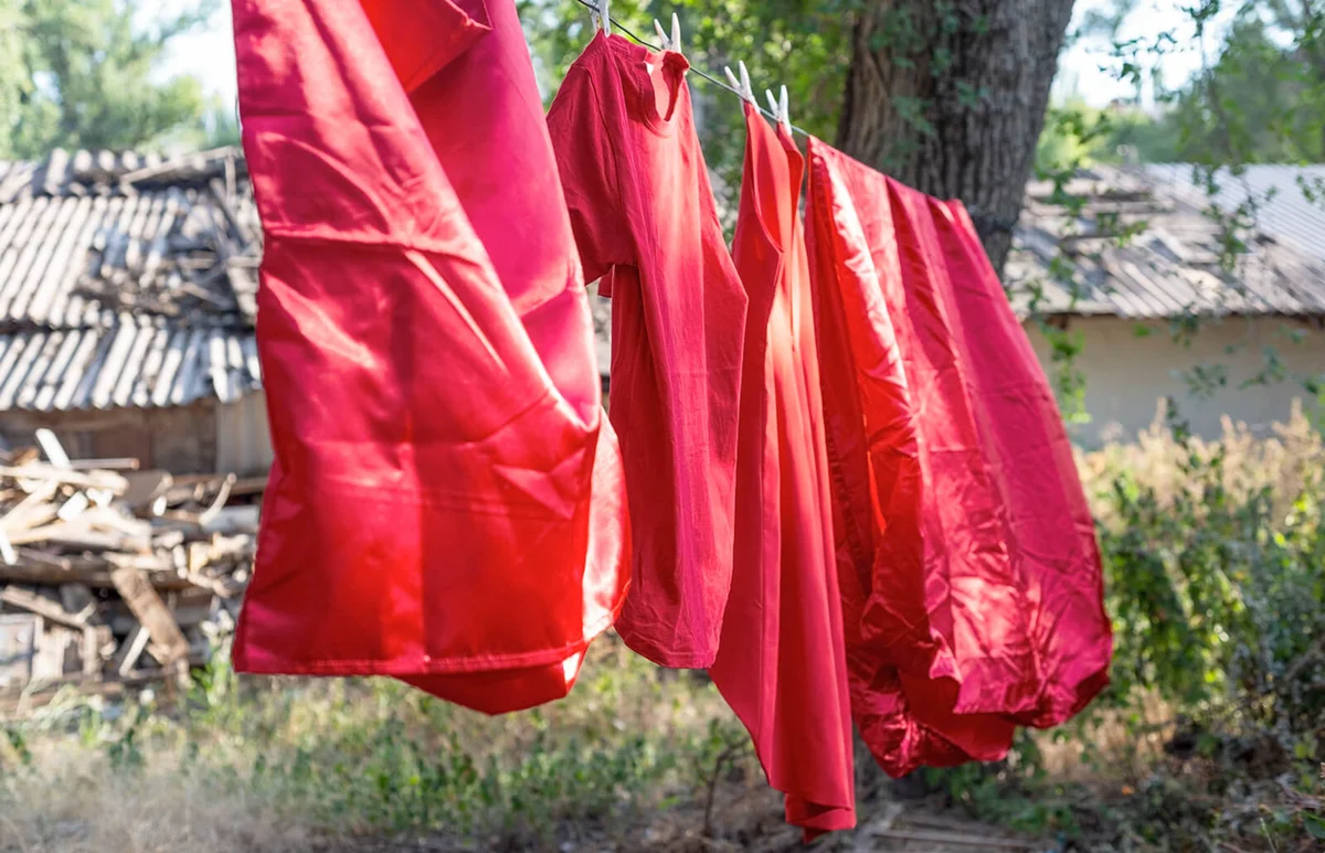 red silk bedding, sheets, rope dry, hanging outside