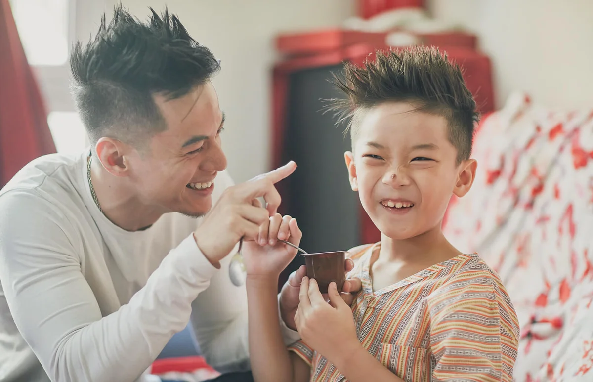 Father and son enjoying eating breakfast at home