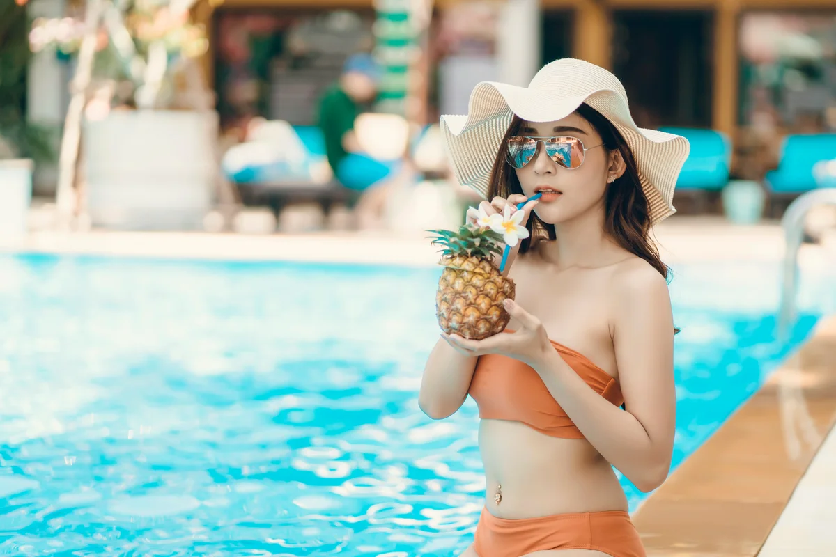 Woman Having Pineapple Drink At Poolside