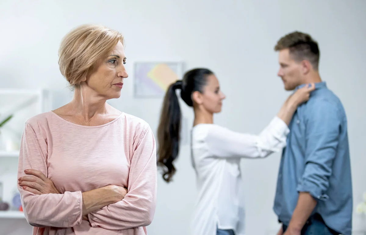 Mother-in-law with hands crossed disapproving young couple relations, loneliness