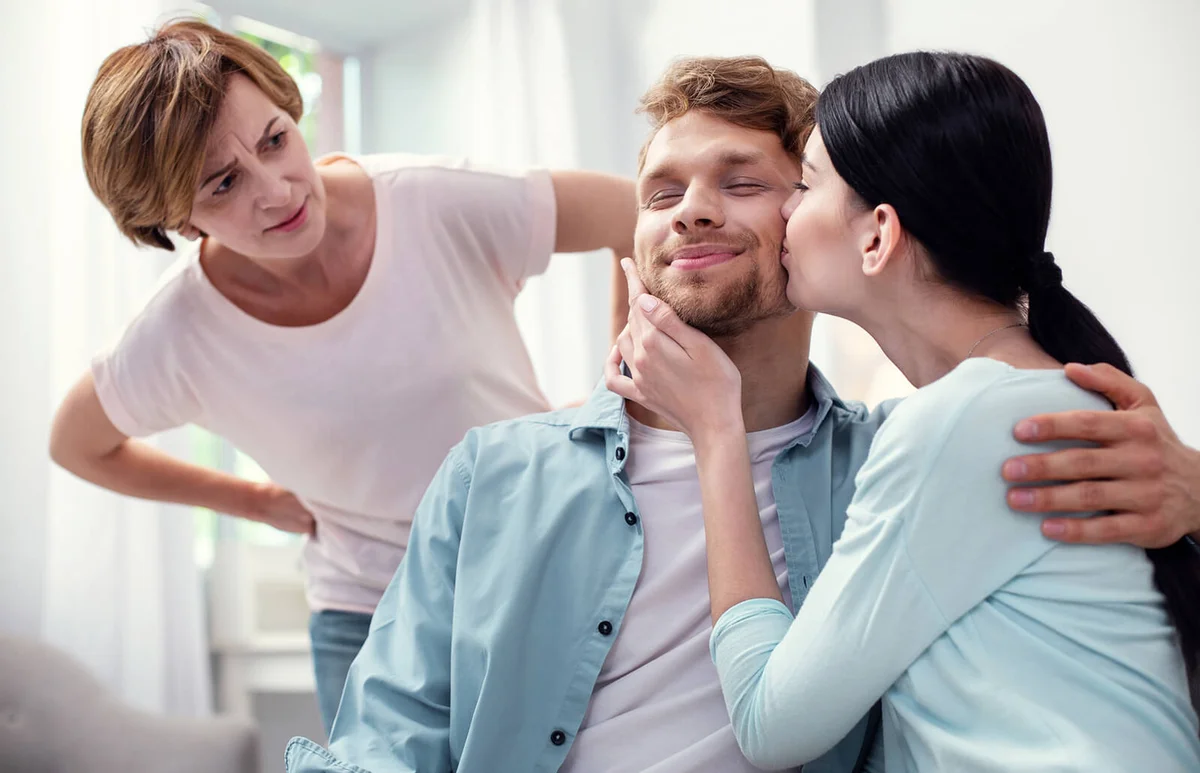 Nice young woman kissing her husband while showing her love