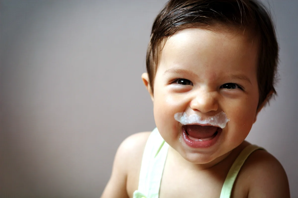 Small boy smiling with milk moustache