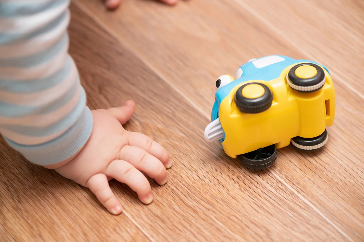 Child is playing with small car