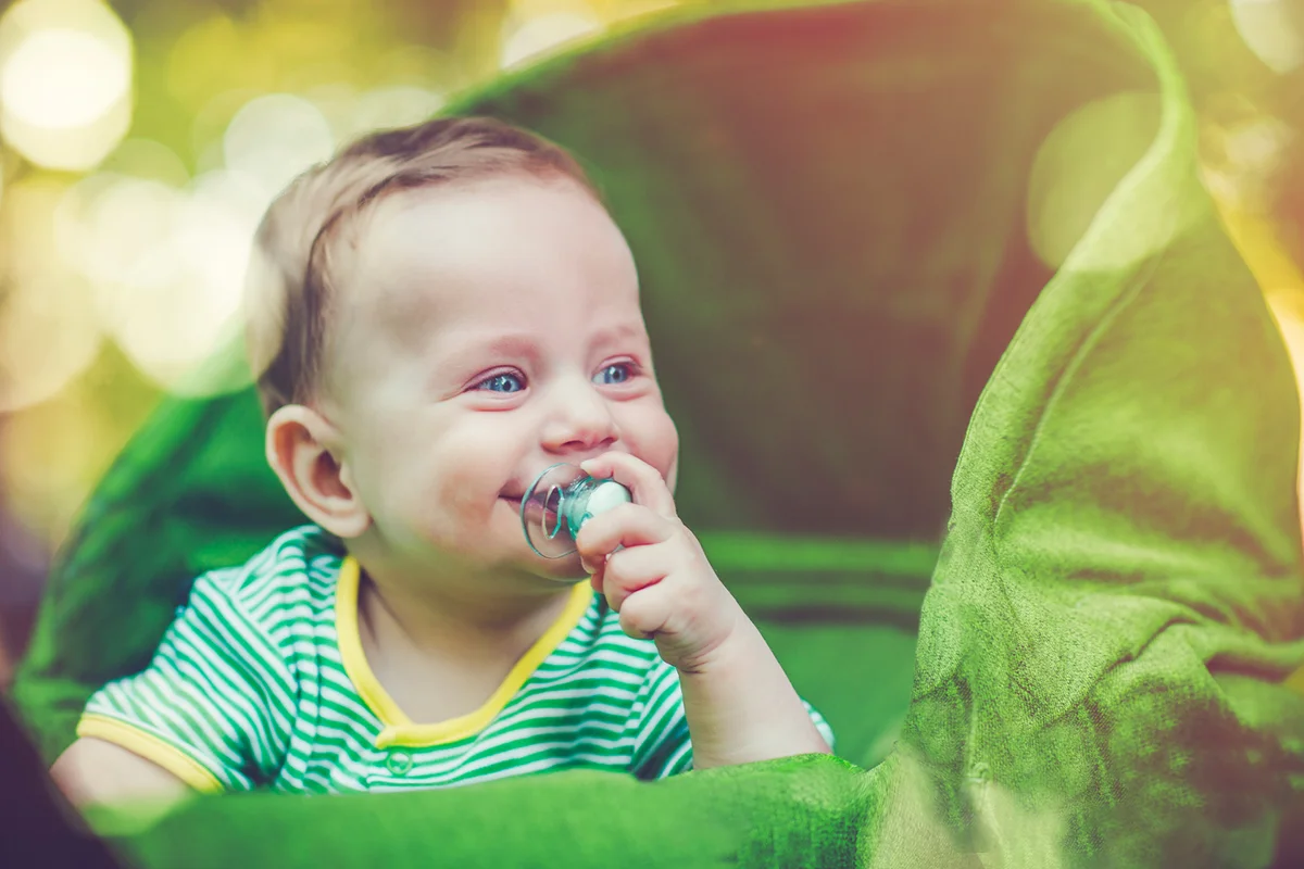 Cute baby in carriage outdoors in summer