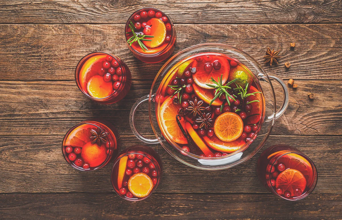 Christmas punch. Festive red cocktail, drink with cranberries and citrus fruits in a punch bowl and glasses