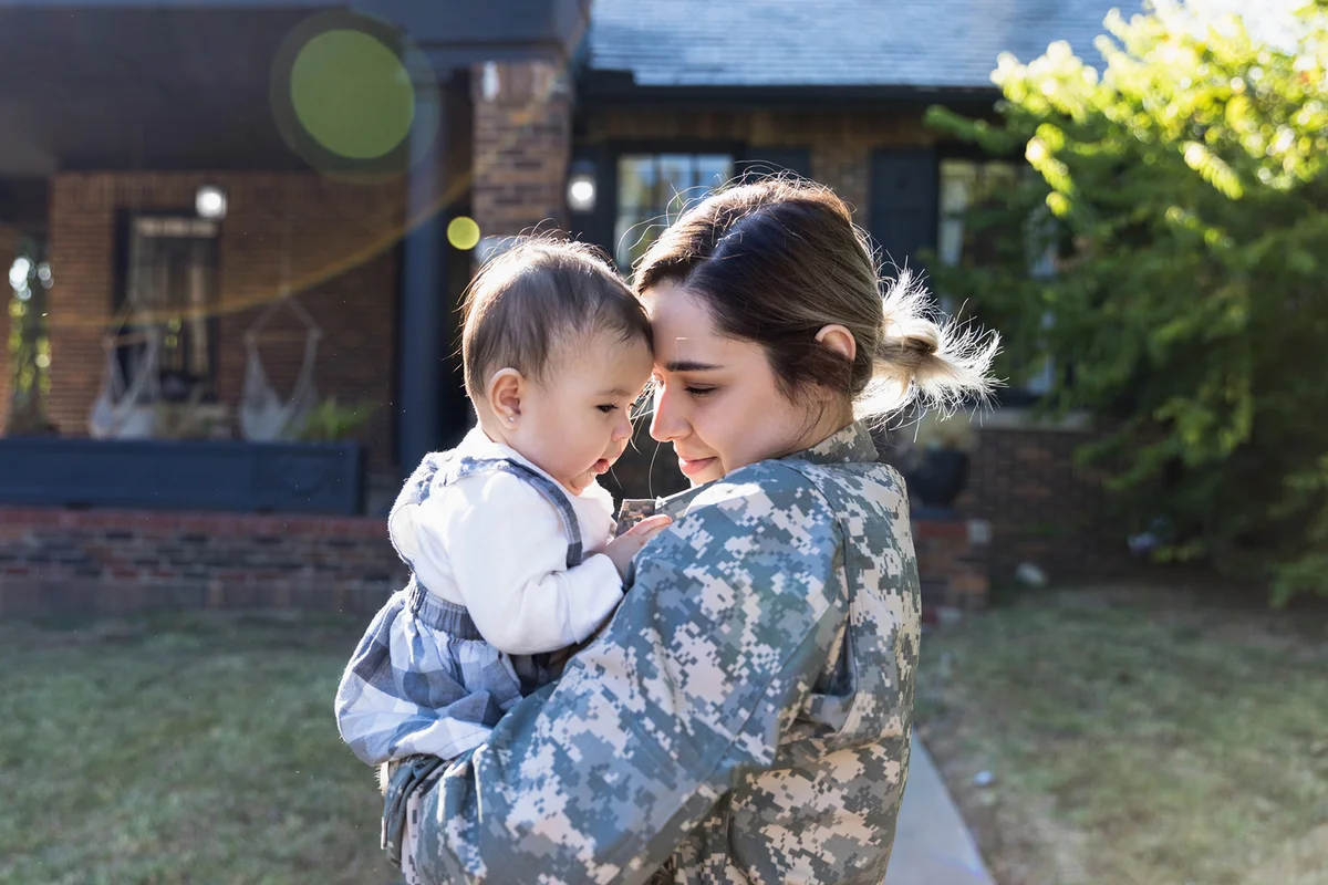 Female soldier enjoys holding daughter