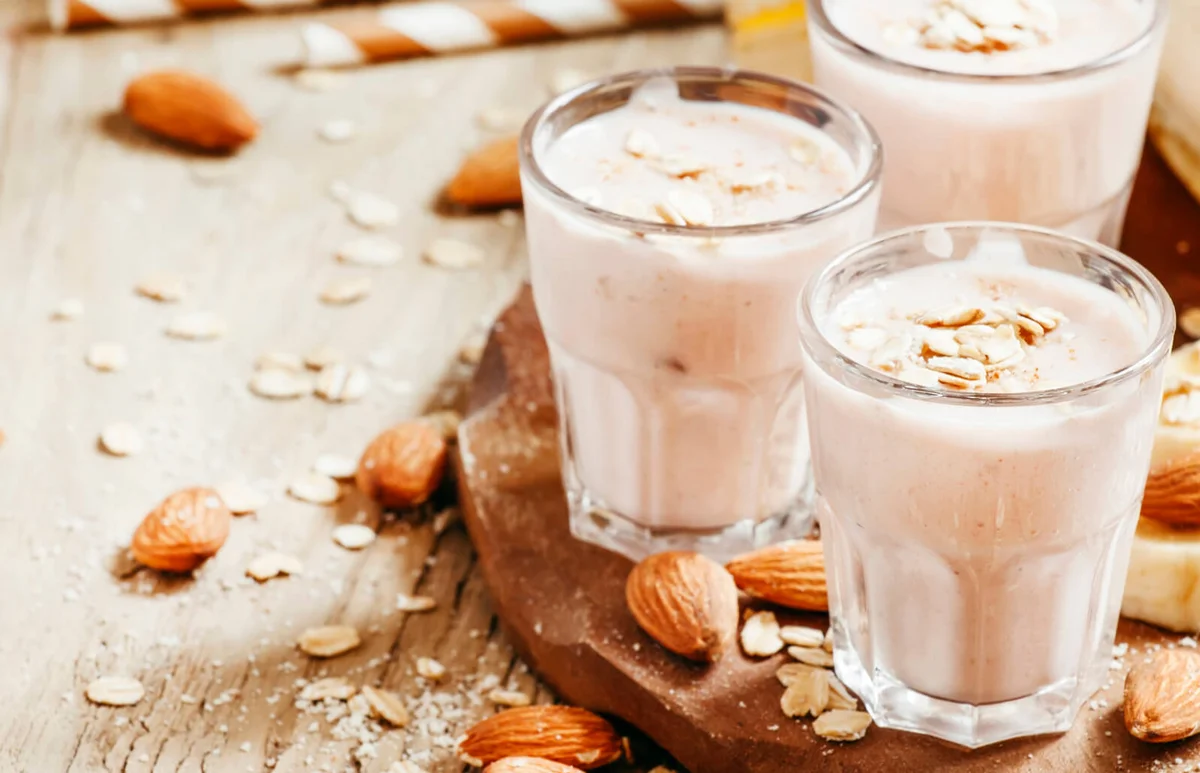 Almonds, banana slices and shot glasses of milk
