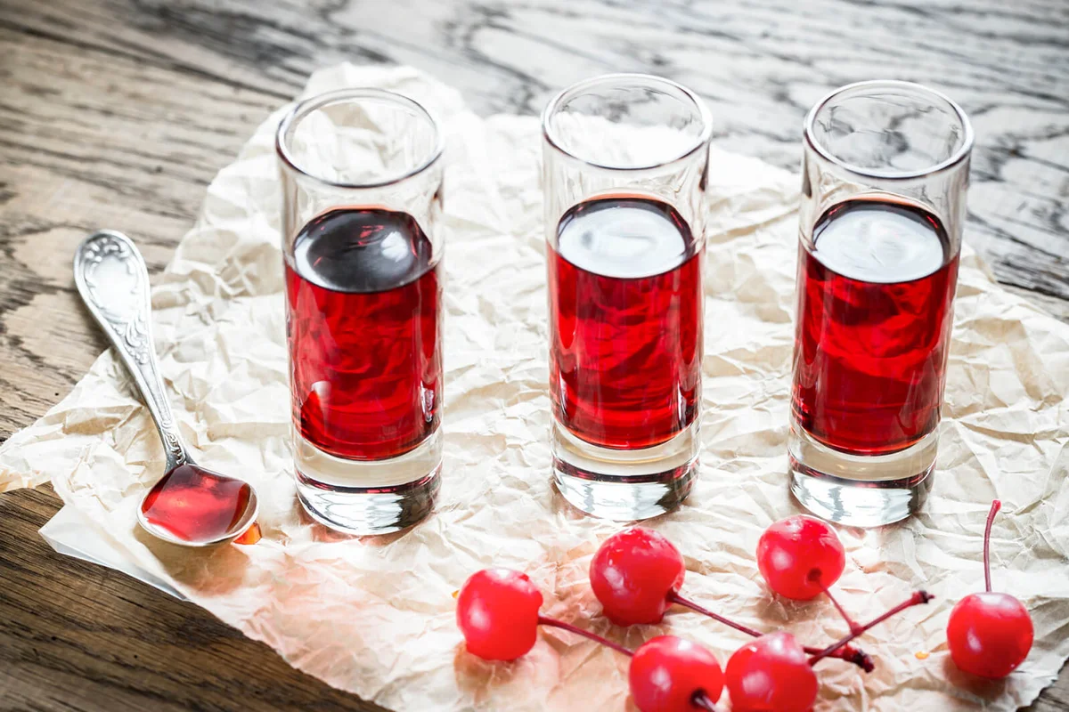 Glasses of cherry brandy with cocktail cherries