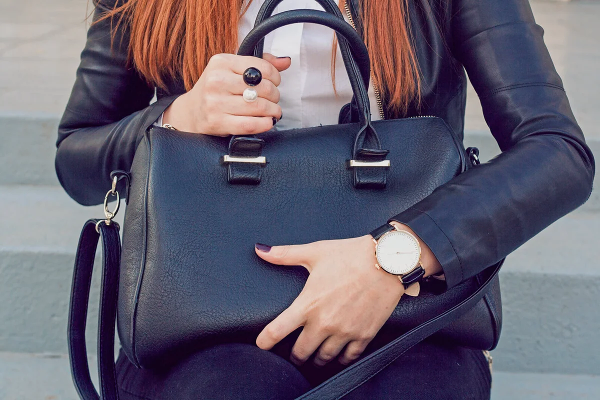 Trendy young girl holding big black handbag street