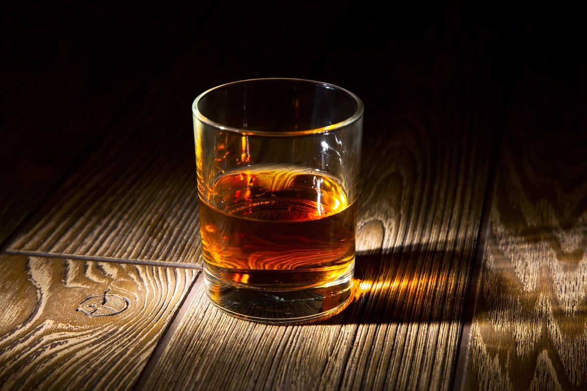 Glass of whiskey on a wooden table