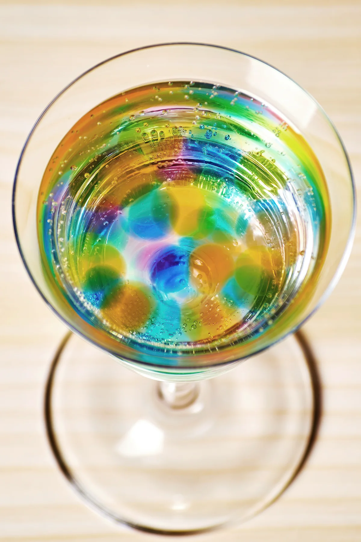 Glass with many colorful jelly balls and fizzy drink inside