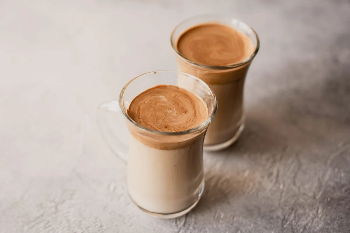 Dalgona coffee In a transparent glass on a marble background