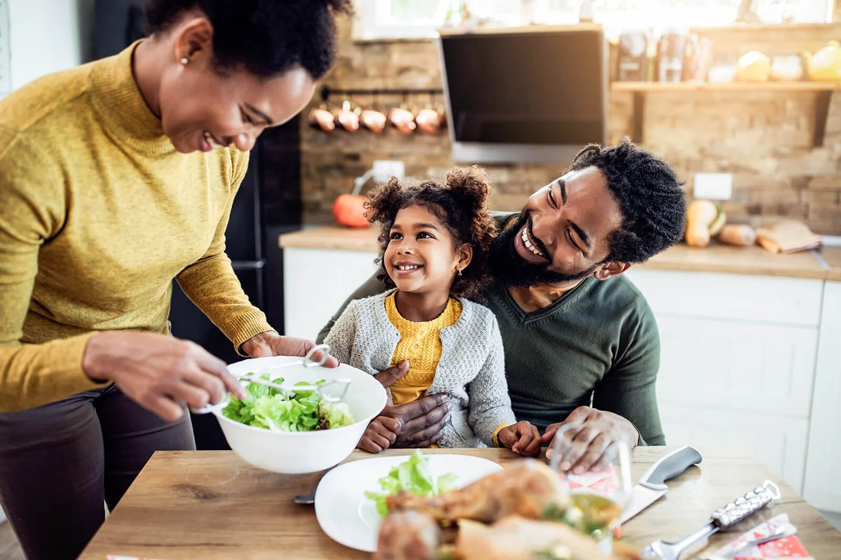 girl having Thanksgiving lunch with her parents at dining table