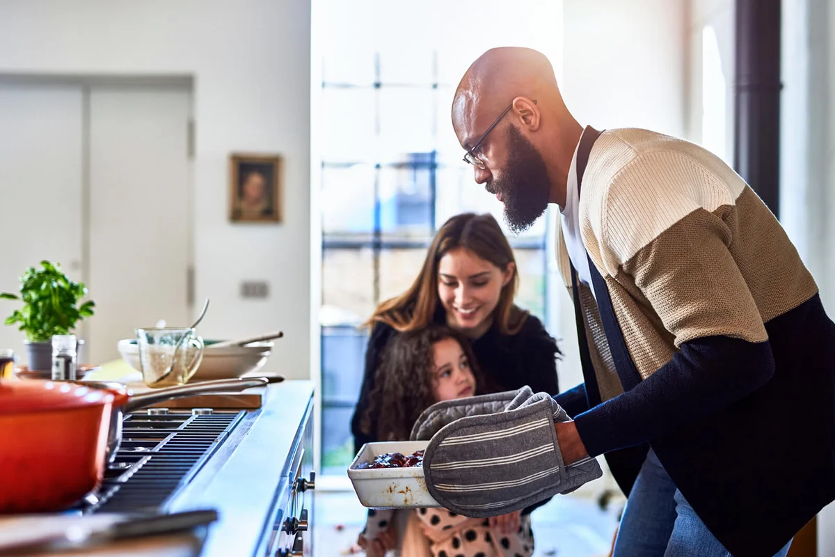 Father making dinner with mother and daughter at home