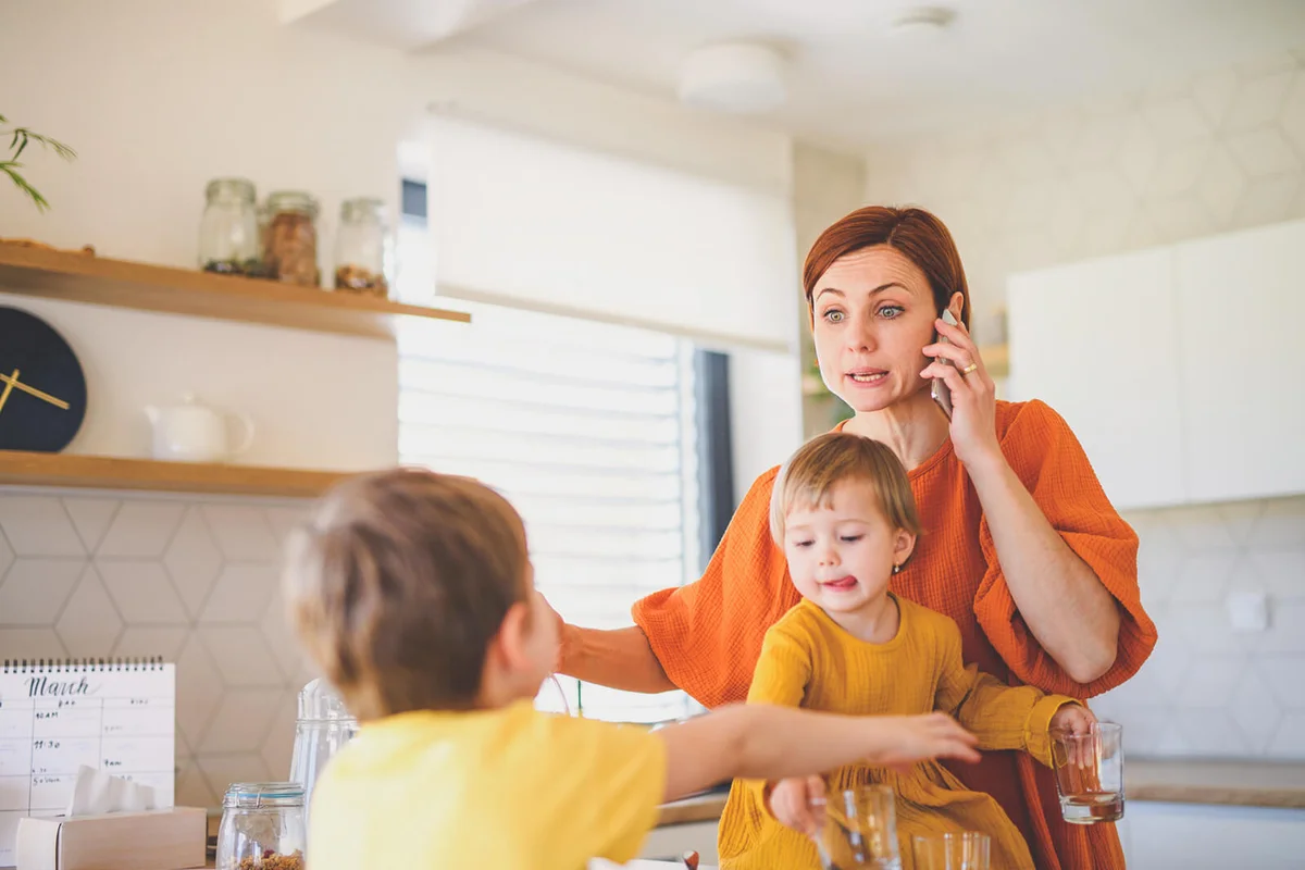 Stressed woman with son and daughter preparing breakfast