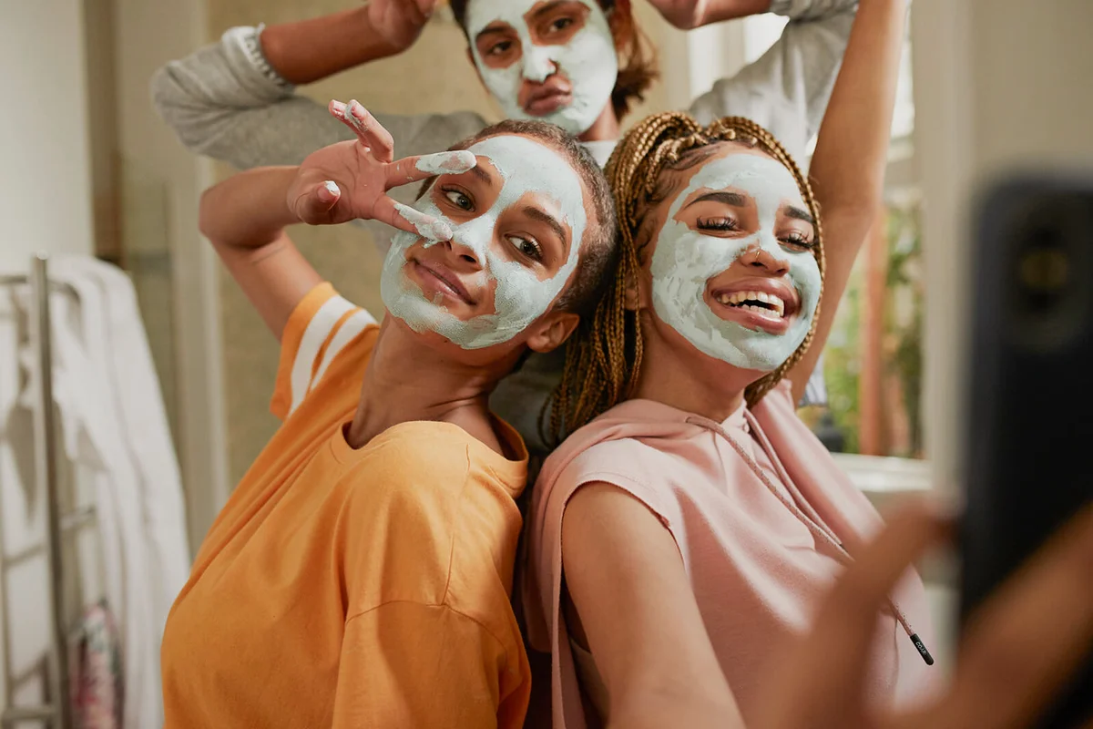 Happy woman taking selfie with friends wearing cream
