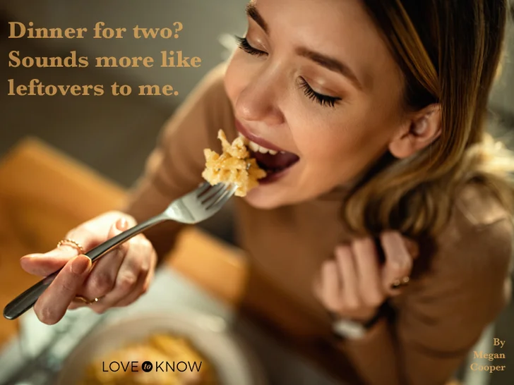 Young happy woman eating pasta at dining table