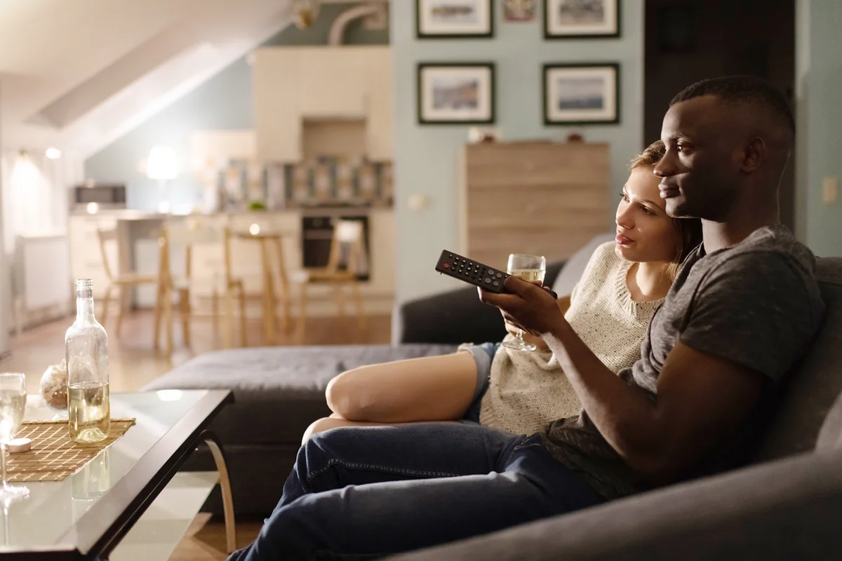Loving multiracial couple watching movie during date