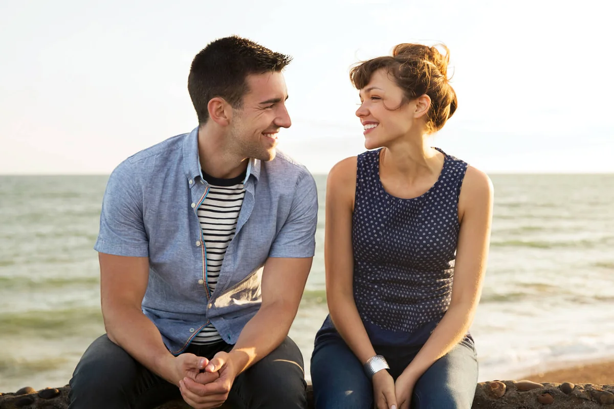 Man and woman sat on wall together