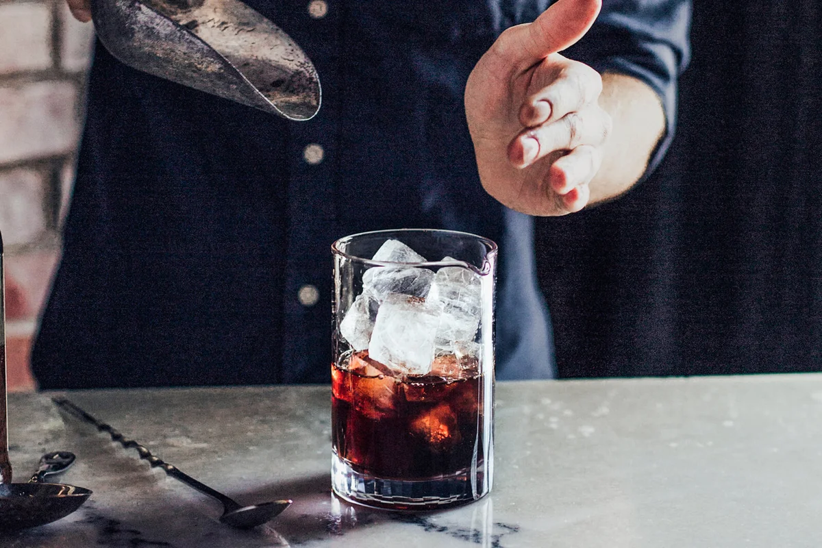 bartender pouring ice in cocktail