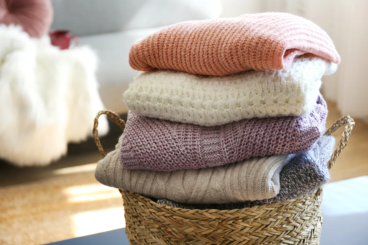 Pile of knitted sweaters of different colors and patterns perfectly stacked