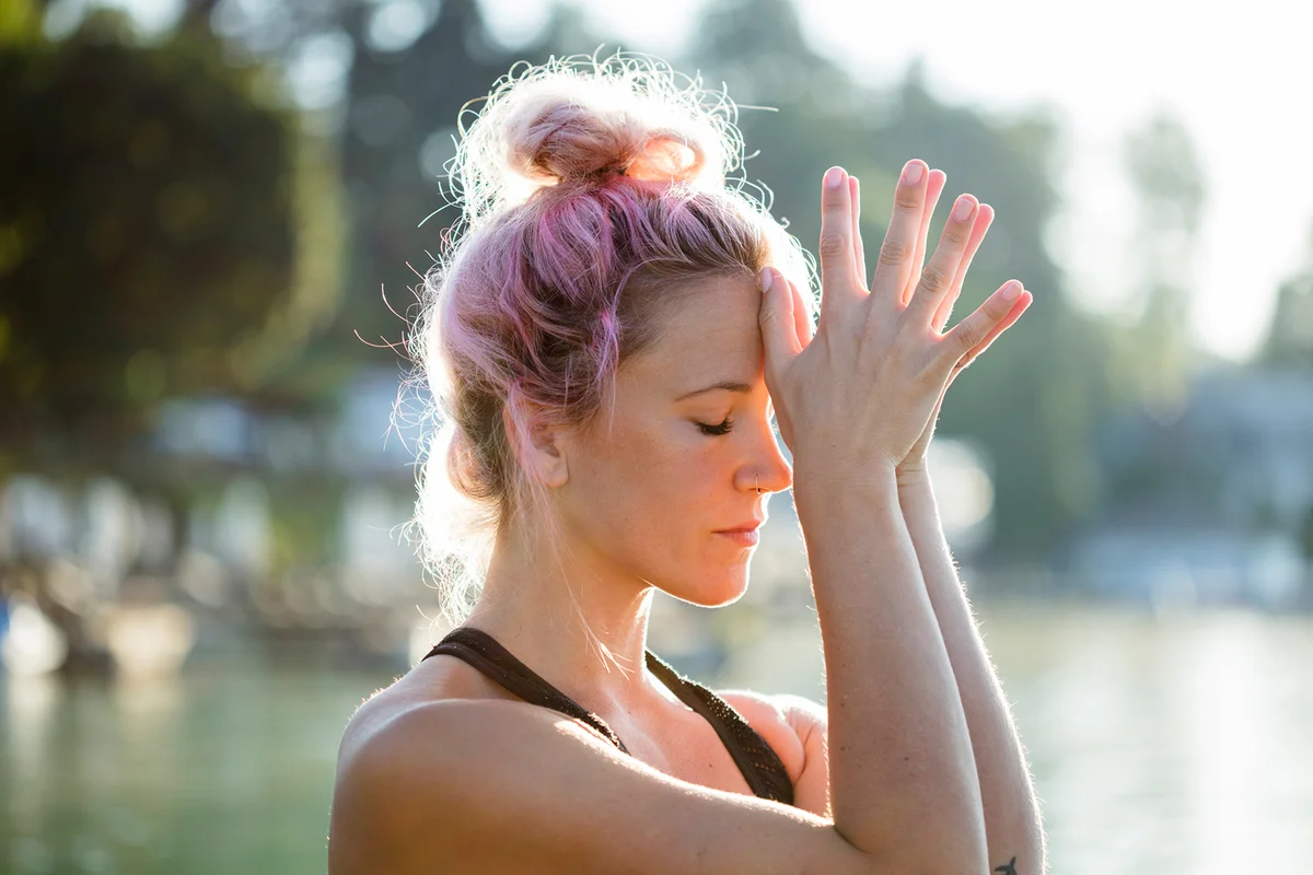 Woman meditating at a lake