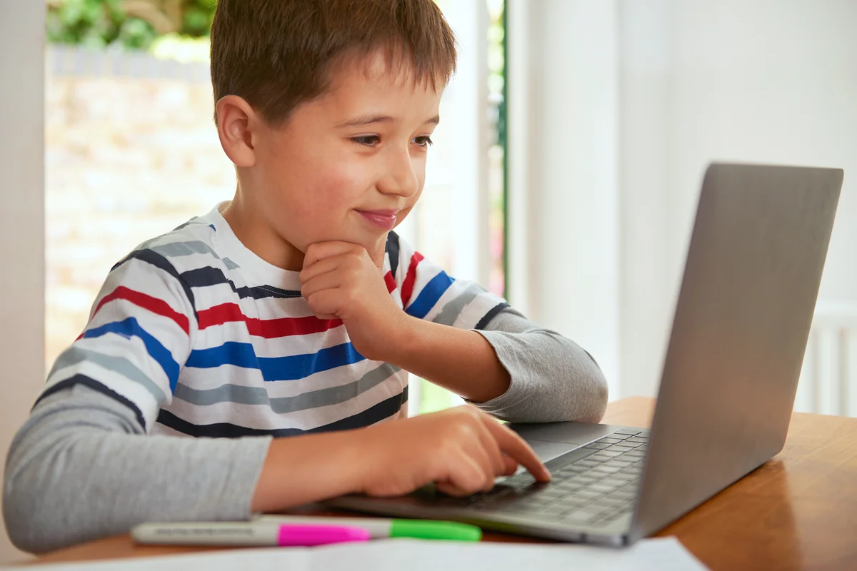 Happy boy playing on computer