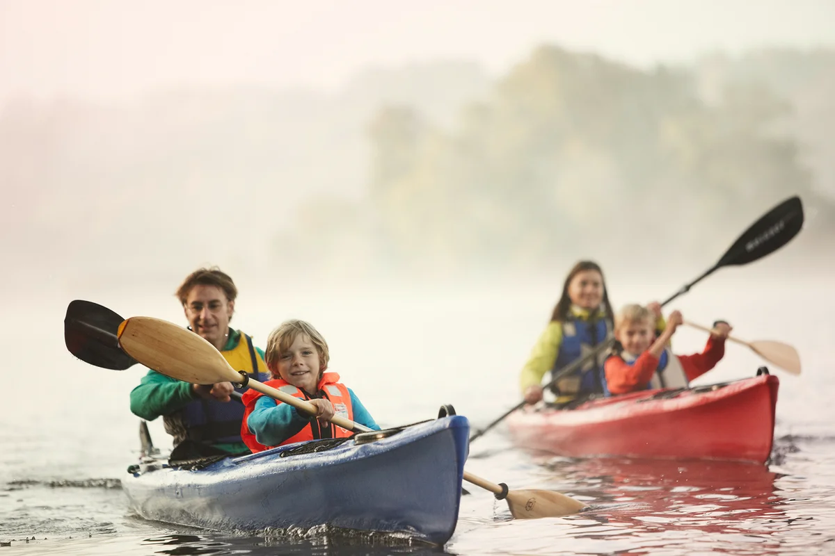 Family paddling in a canoe on a lake